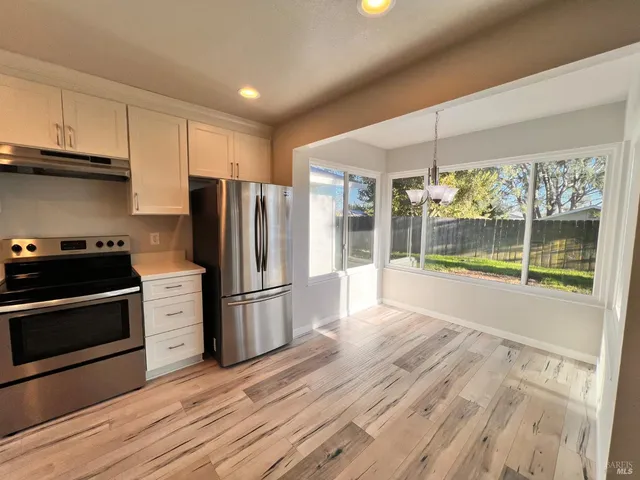 a kitchen with granite countertop a refrigerator and a stove