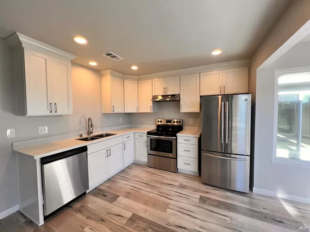 a kitchen with a refrigerator sink and cabinets
