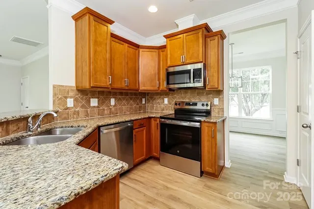 a kitchen with granite countertop a stove sink and microwave