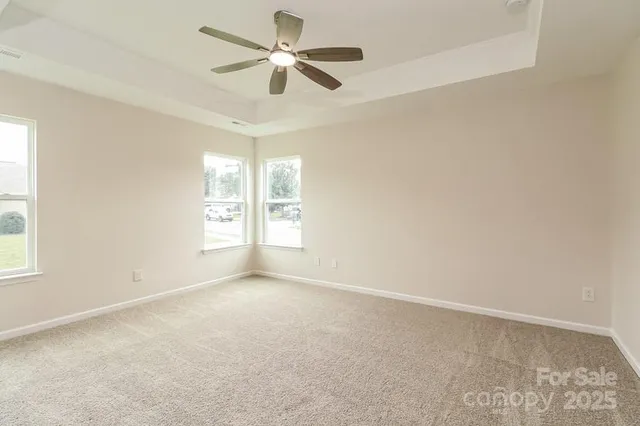 an empty room with windows and ceiling fan