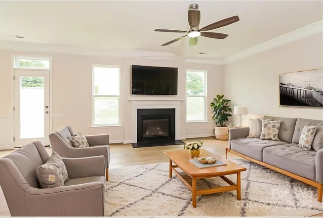 a living room with furniture a flat screen tv and a fireplace