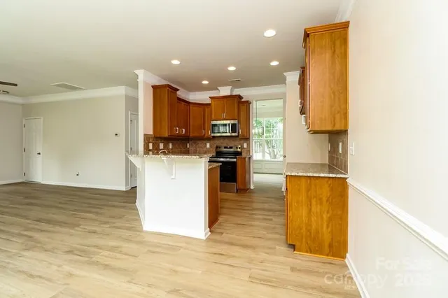 a view of kitchen with cabinets microwave and stove