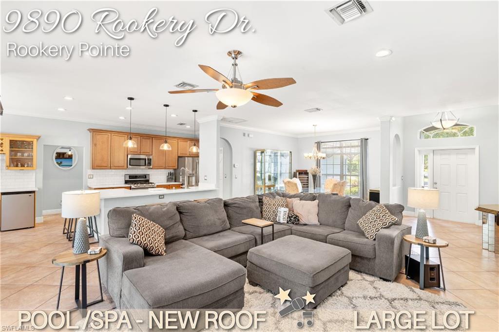 a living room with furniture kitchen view and a chandelier