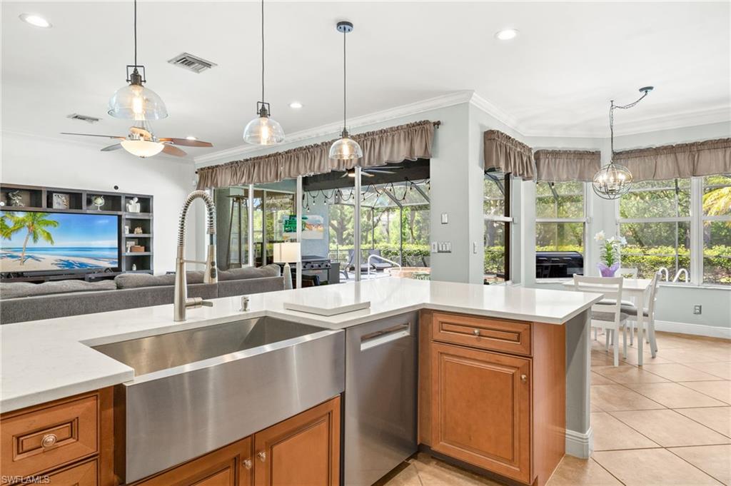 9890 Rookery Circle Estero, FL 33928 - Photo 11 of 26 a kitchen with stainless steel appliances granite countertop a sink a stove and a refrigerator