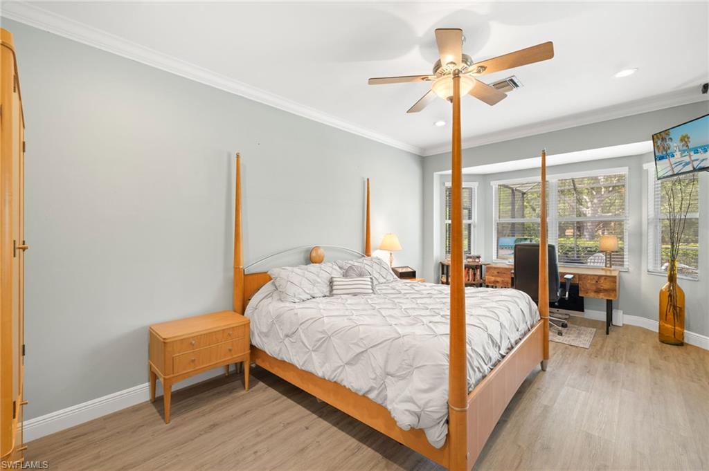 9890 Rookery Circle Estero, FL 33928 - Photo 15 of 26 a bedroom with a bed and a chandelier