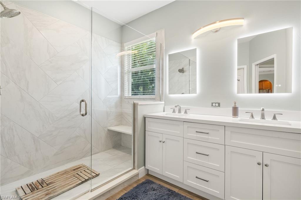 9890 Rookery Circle Estero, FL 33928 - Photo 17 of 26 a bathroom with a shower sink and mirror