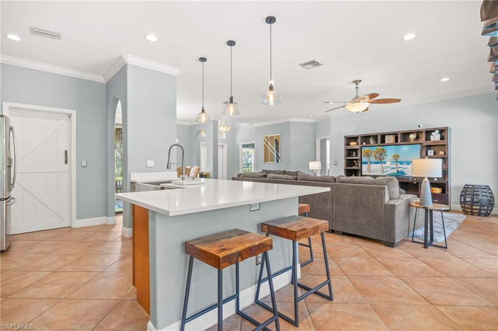 9890 Rookery Circle Estero, FL 33928 - Photo 9 of 26 a dining hall with stainless steel appliances kitchen island a table chairs and a sink