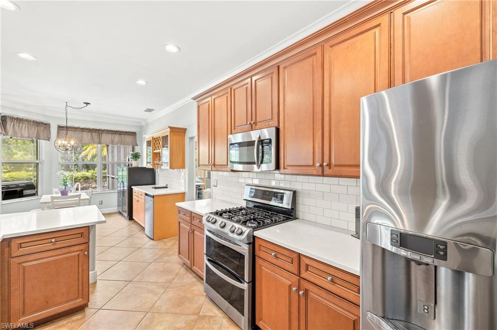 9890 Rookery Circle Estero, FL 33928 - Photo 10 of 26 a kitchen with stainless steel appliances granite countertop a refrigerator stove and sink