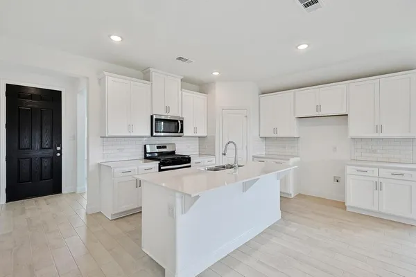 a kitchen with stainless steel appliances a sink stove and refrigerator