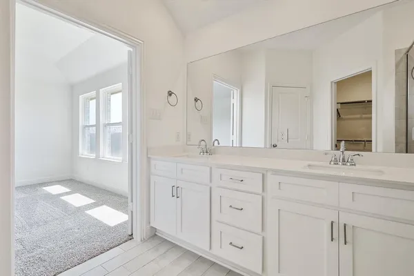 a bathroom with double sink and a mirror