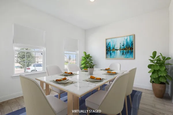 a dining room with furniture potted plants and wooden floor