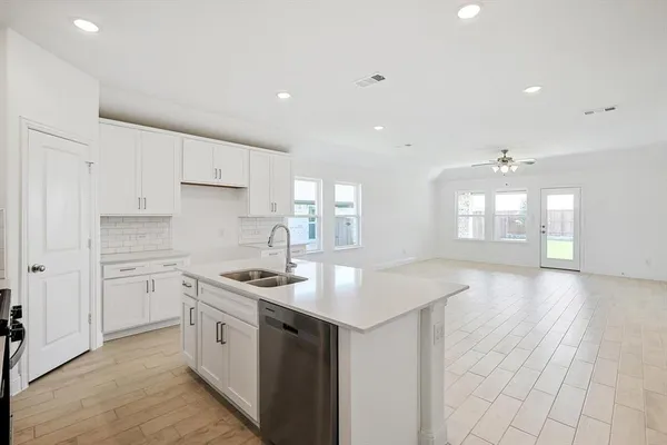 a kitchen that has a sink a stove and cabinets