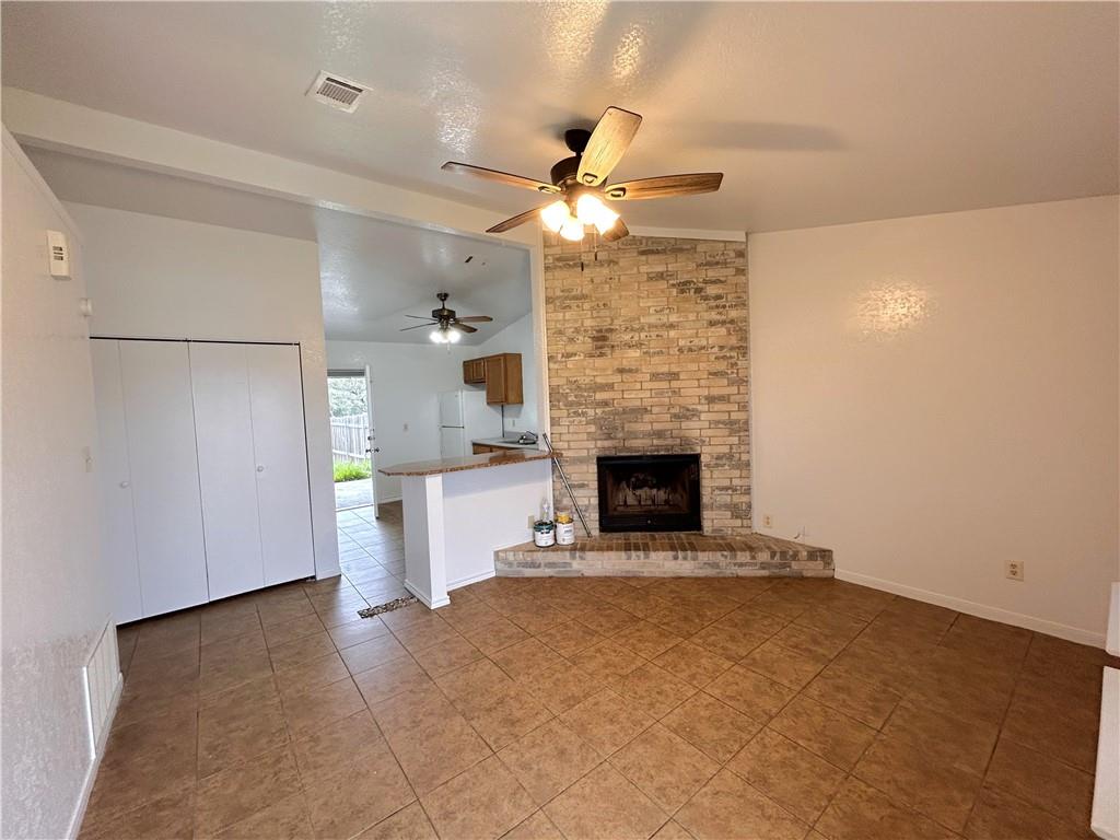 10411 Chaparral Road Killeen, TX 76548 - Photo 2 of 6 A corner brick fireplace adds warmth and character to this open-concept living area.