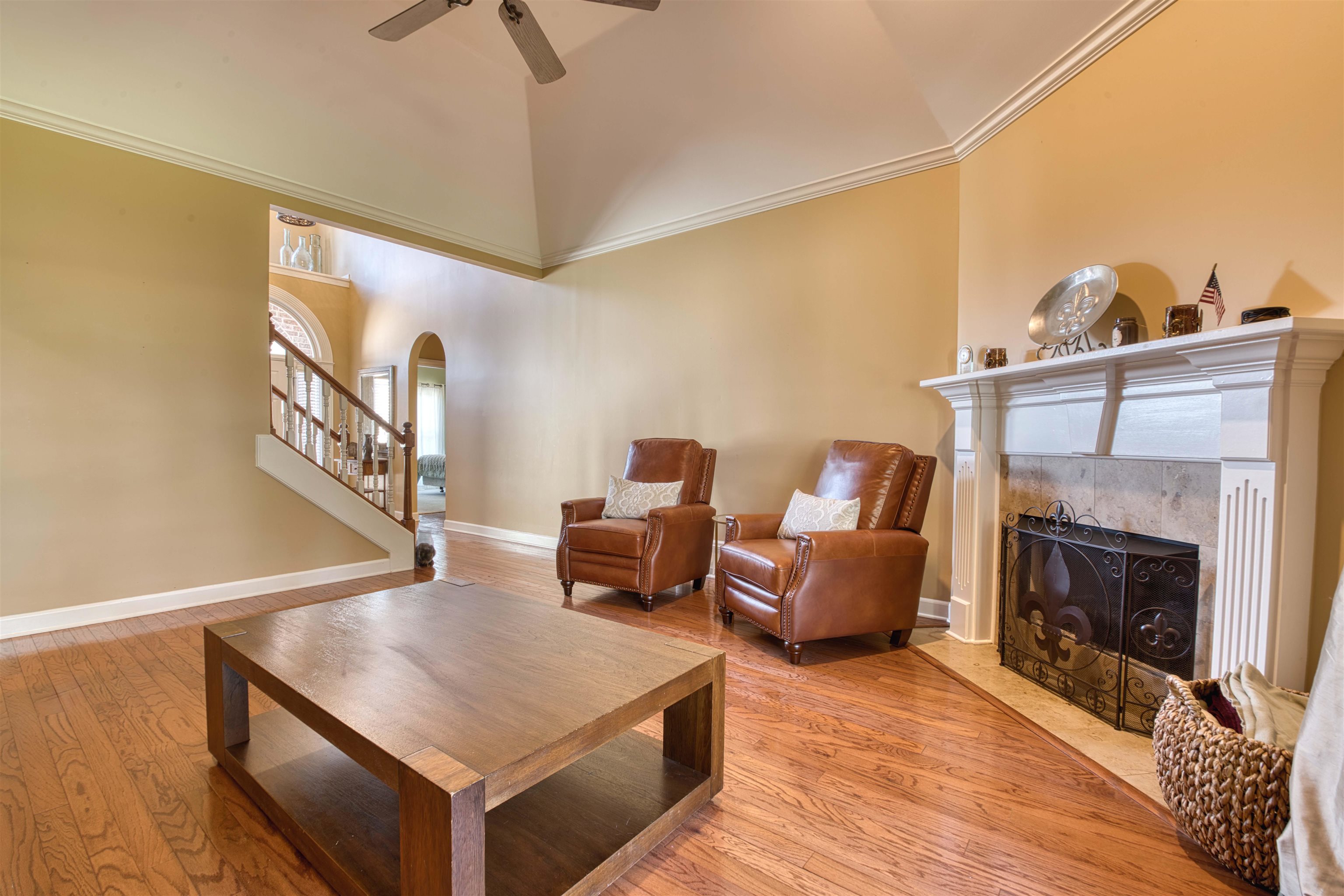 1630 Wolf Ridge Drive Collierville, TN 38017 - Photo 8 of 38 Living area with a tiled fireplace, high vaulted ceiling, ceiling fan, arched walkways, and wood finished floors