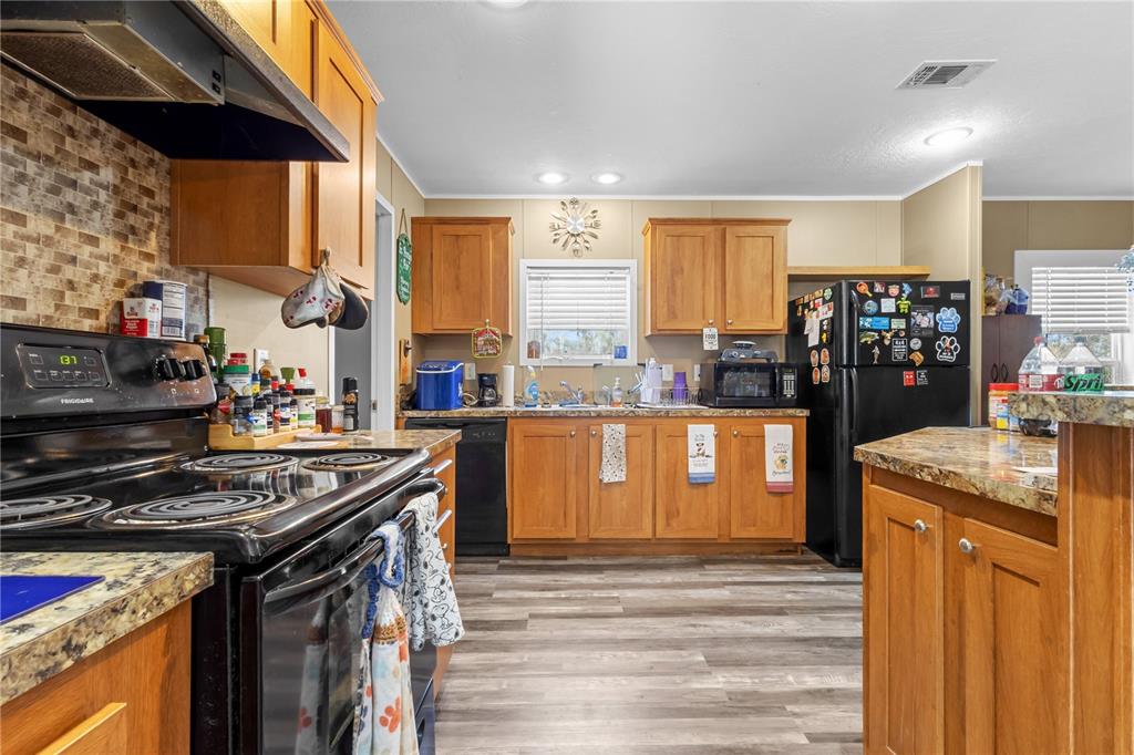 1650 Lyman Hendry Road, Unit 1 Perry, FL 32347 - Photo 11 of 30 a kitchen with stainless steel appliances granite countertop a stove a sink and a refrigerator