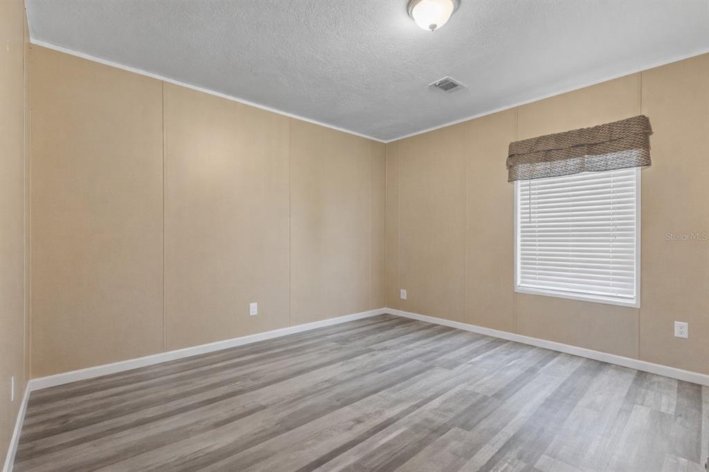 1650 Lyman Hendry Road, Unit 1 Perry, FL 32347 - Photo 15 of 30 a view of an empty room with wooden floor and a window