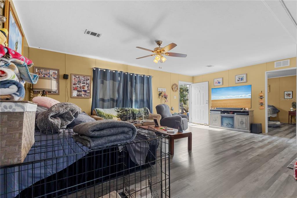 1650 Lyman Hendry Road, Unit 1 Perry, FL 32347 - Photo 6 of 30 a living room with furniture a fireplace and a flat screen tv