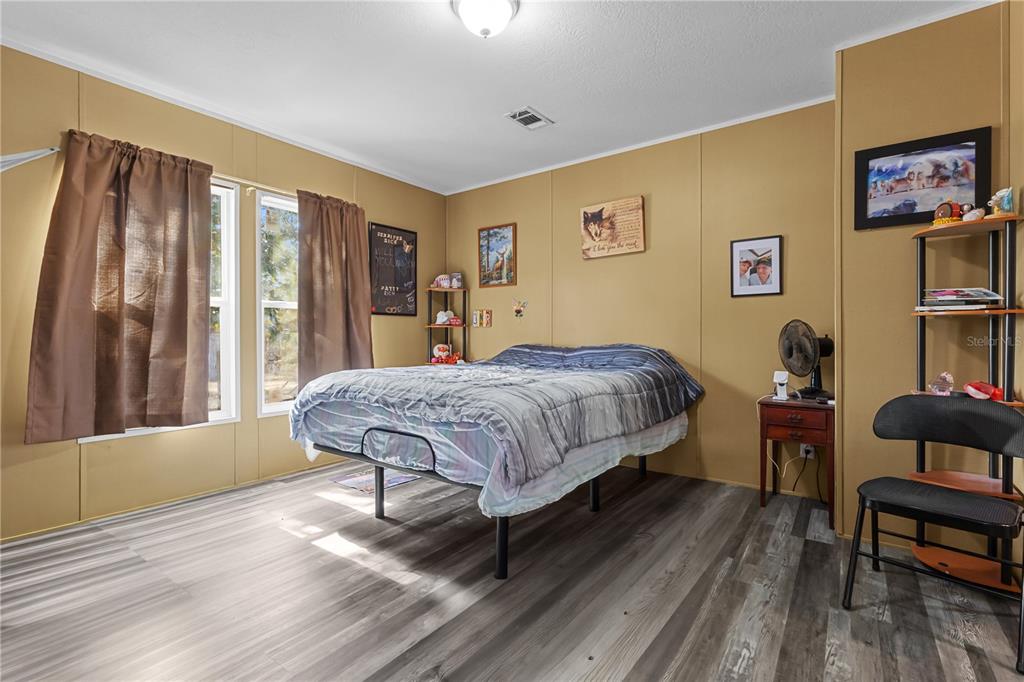 1650 Lyman Hendry Road, Unit 1 Perry, FL 32347 - Photo 7 of 30 a bedroom with a bed and wooden floor