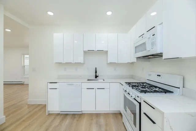 a kitchen with stainless steel appliances granite countertop a sink stove and cabinets
