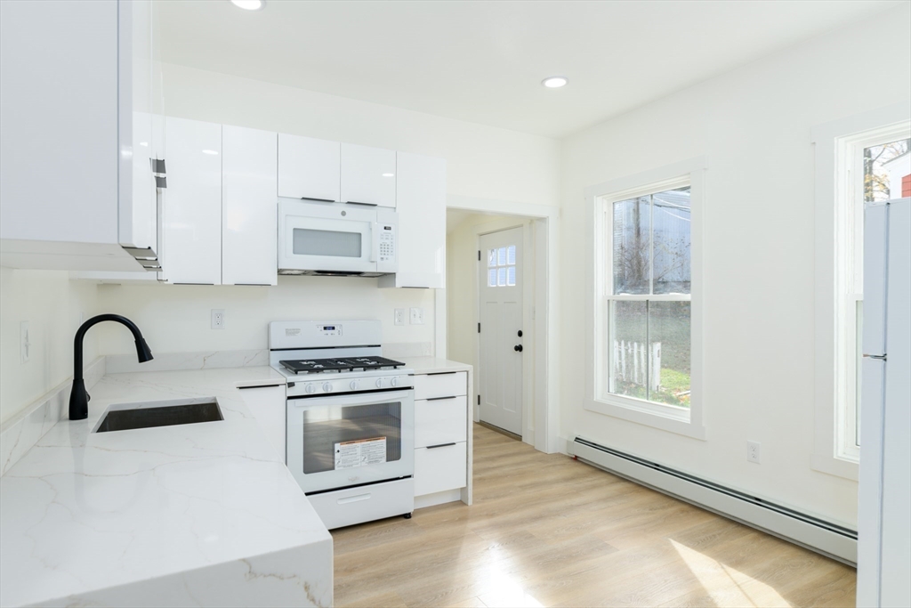 33 Florence Street Worcester, MA 01610 - Photo 15 of 36 a kitchen with stainless steel appliances granite countertop a stove a sink and a refrigerator