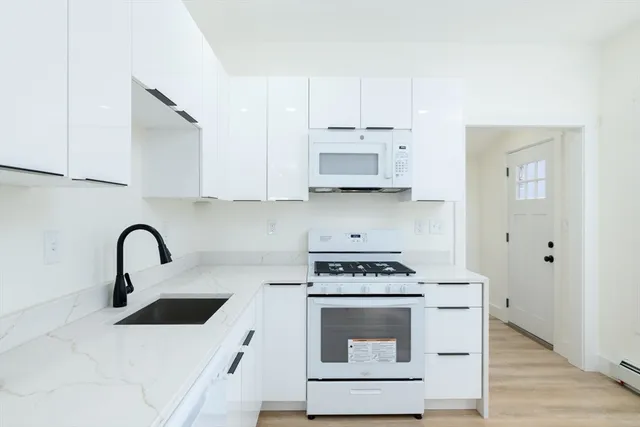 a kitchen with stainless steel appliances a stove a sink and a white counter space
