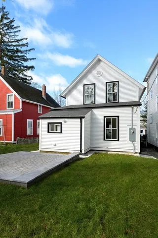 a view of a yard in front of a house with large windows