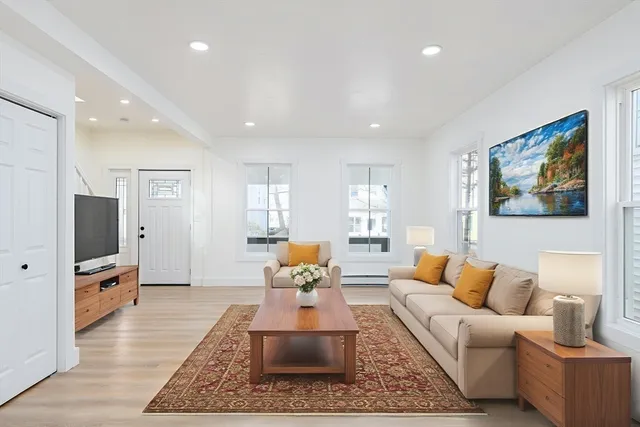 a living room with furniture wooden floor and a flat screen tv