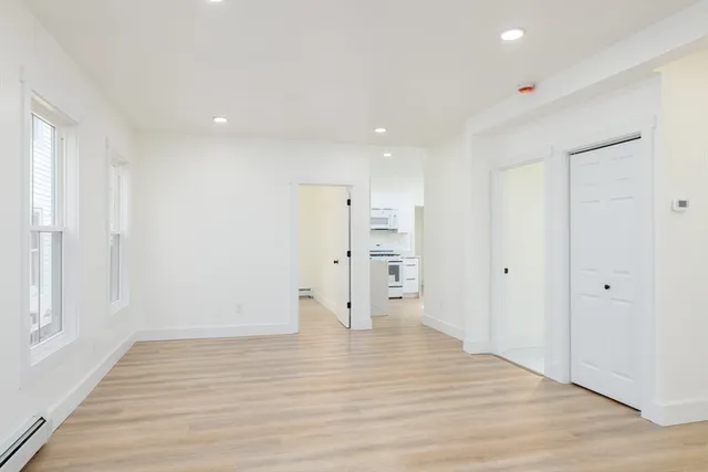 a view of empty room with wooden floor