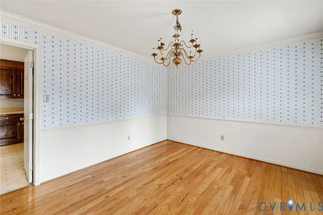 a view of a room with wooden floor and chandelier