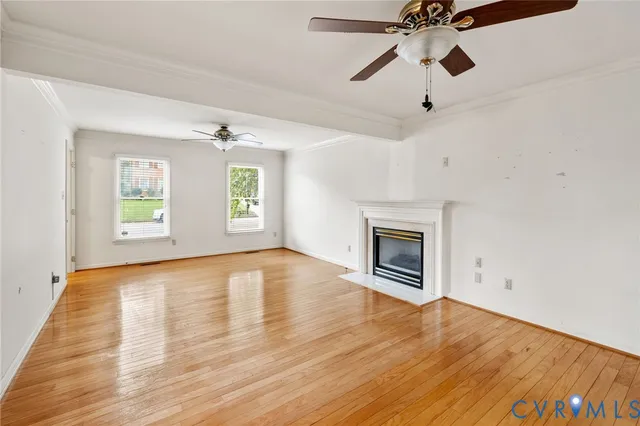 a view of empty room with wooden floor and fireplace