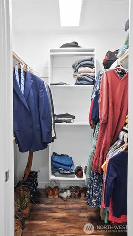 a view of walk in closet with clothes and shoes