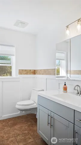 a bathroom with a sink a toilet and mirror