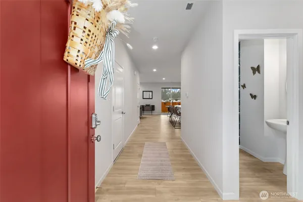 a view of a hallway with wooden floor and staircase