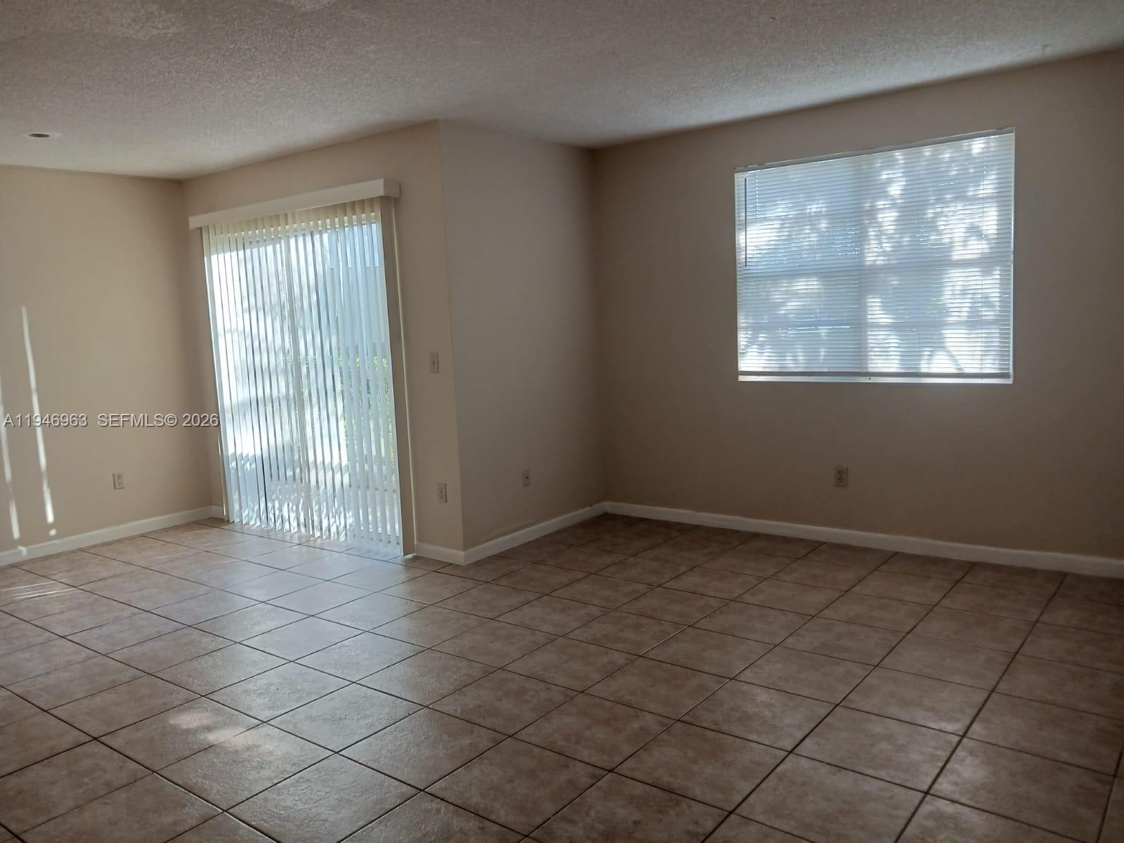 1239 Southwest 46th Avenue, Unit 903 Pompano Beach, FL 33069 - Photo 6 of 16 an empty room with windows