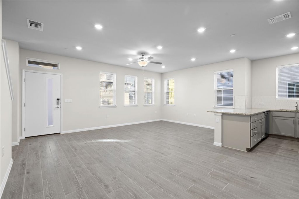 9015 Cattle Baron Path, Unit 705 Austin, TX 78747 - Photo 10 of 35 a view of an empty room with a window and wooden floor
