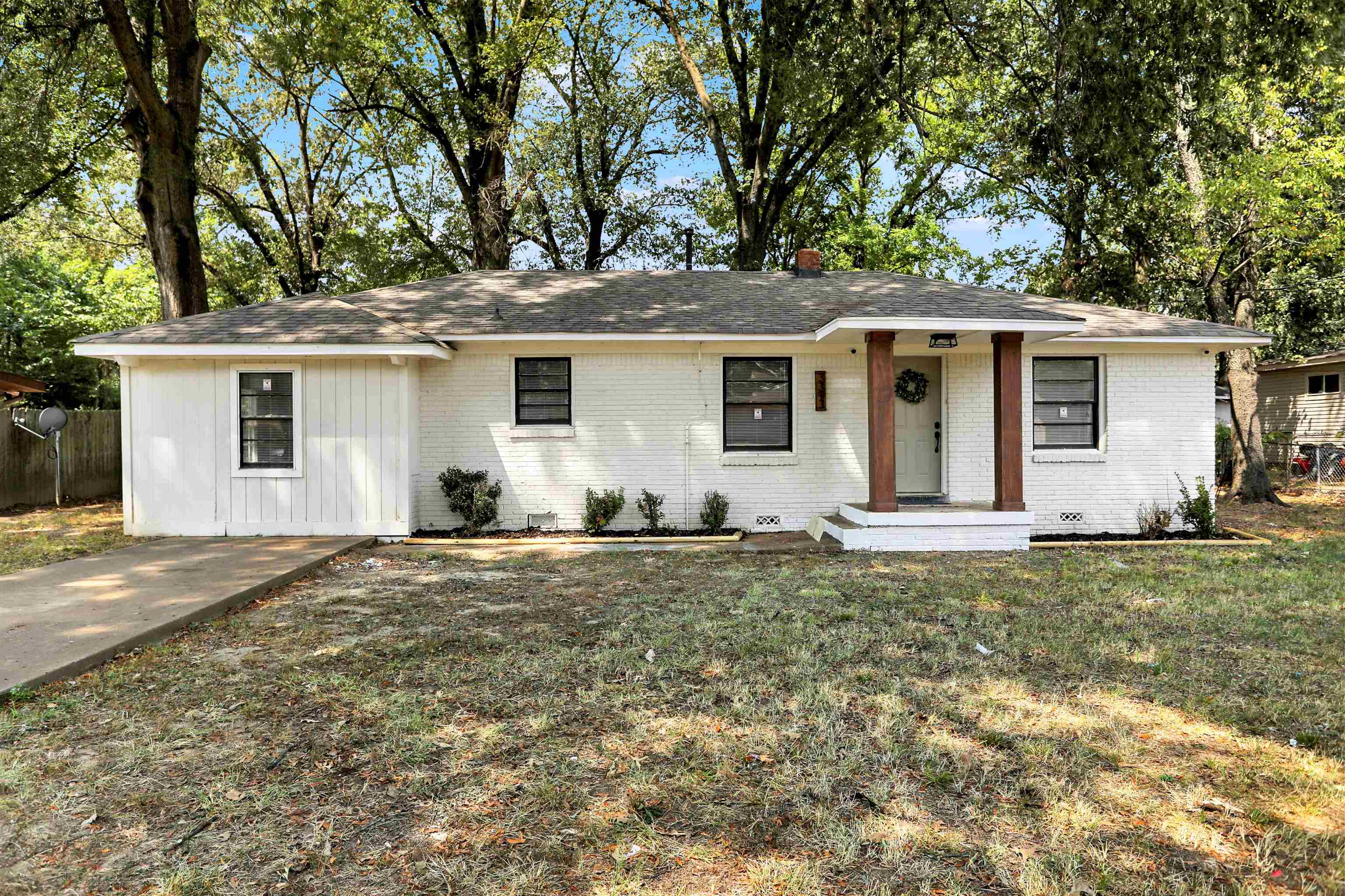 a front view of house with yard and trees