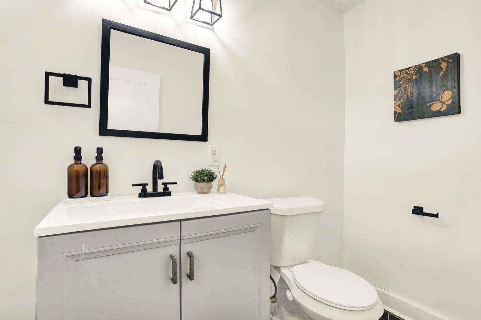 3393 Berea Road Memphis, TN 38109 - Photo 13 of 20 a bathroom with a toilet sink vanity and mirror