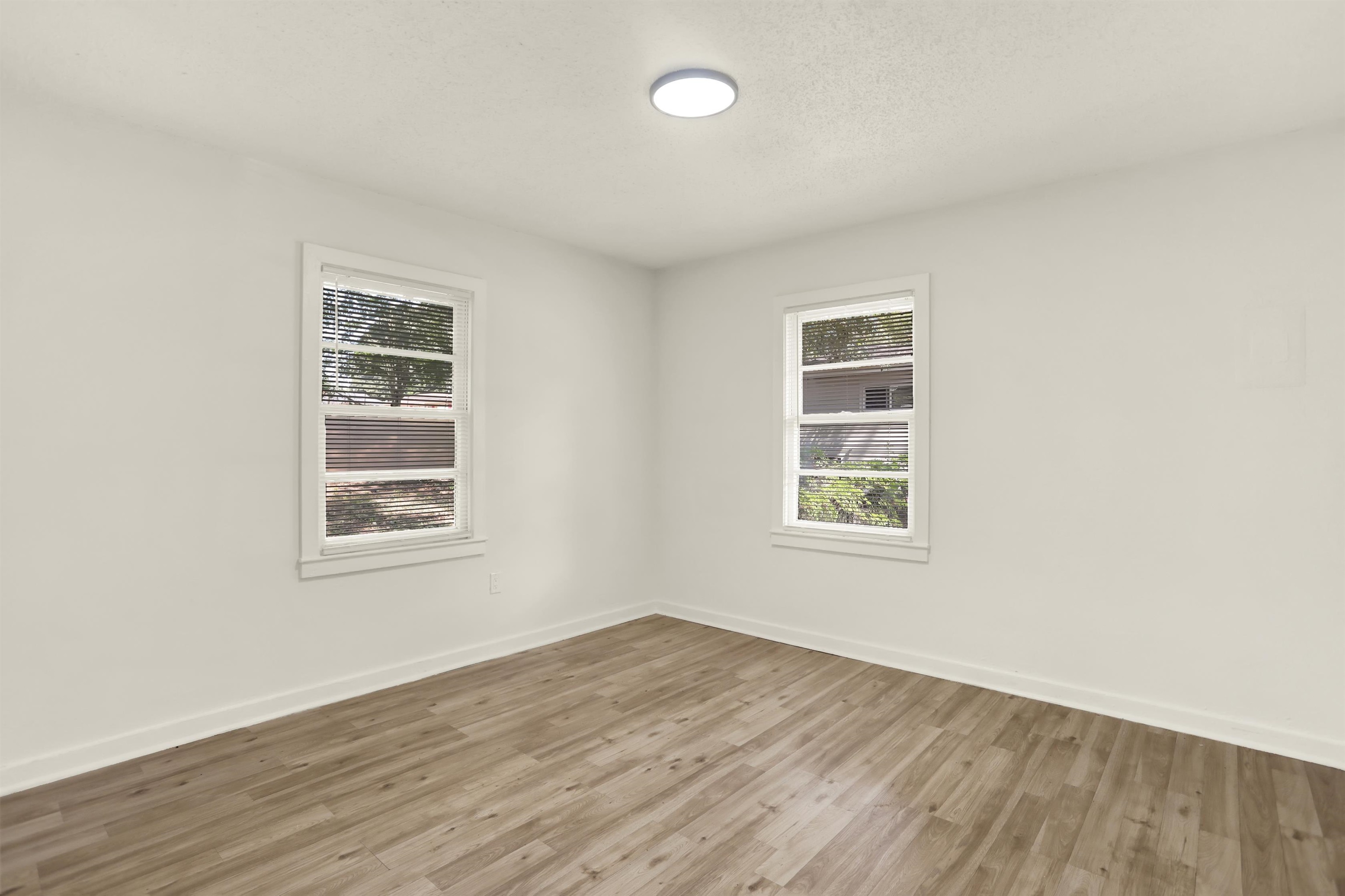 3393 Berea Road Memphis, TN 38109 - Photo 15 of 20 an empty room with wooden floor and windows