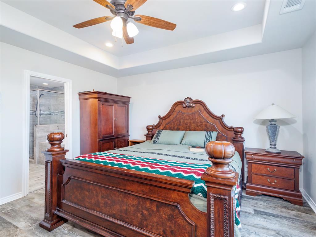 202 East Hall Court Early, TX 76802 - Photo 13 of 34 a bedroom with a bed and a chandelier