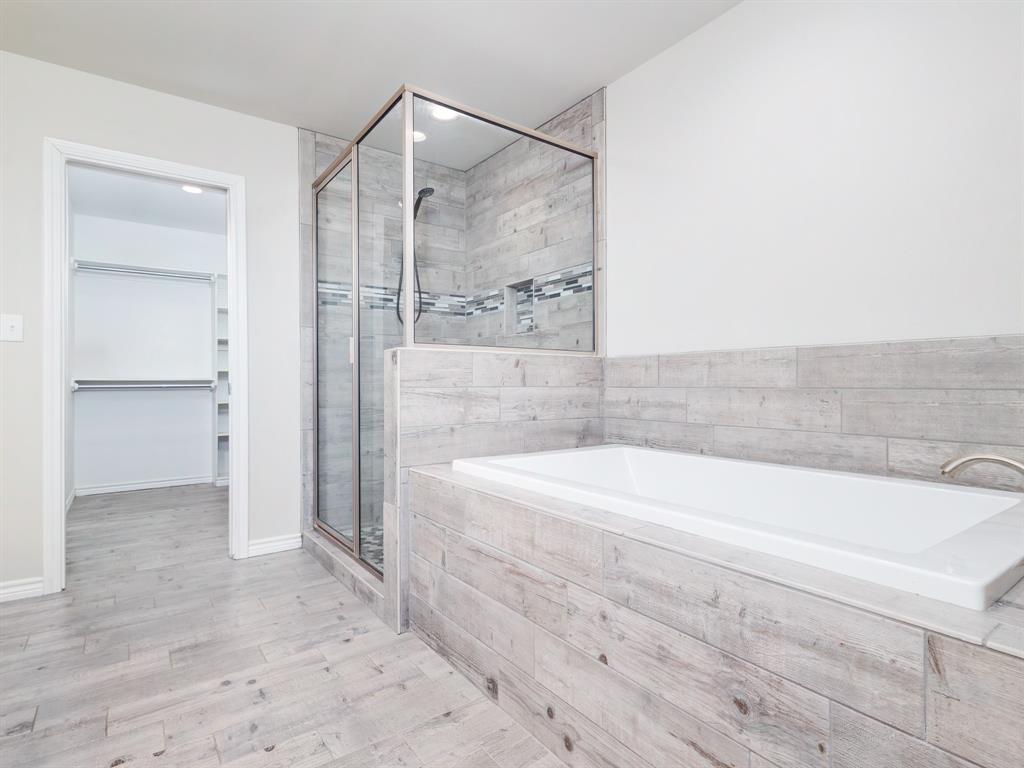 202 East Hall Court Early, TX 76802 - Photo 15 of 34 a bathroom with a bathtub and a shower
