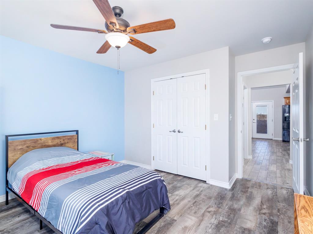 202 East Hall Court Early, TX 76802 - Photo 21 of 34 a bedroom with a bed and a chandelier