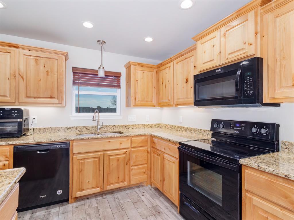 202 East Hall Court Early, TX 76802 - Photo 9 of 34 a kitchen with stainless steel appliances granite countertop a sink stove and microwave