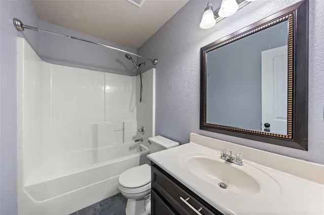 a bathroom with a sink a toilet a mirror and shower