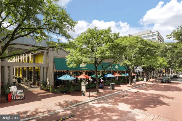 a group of people sitting in front of retail shops