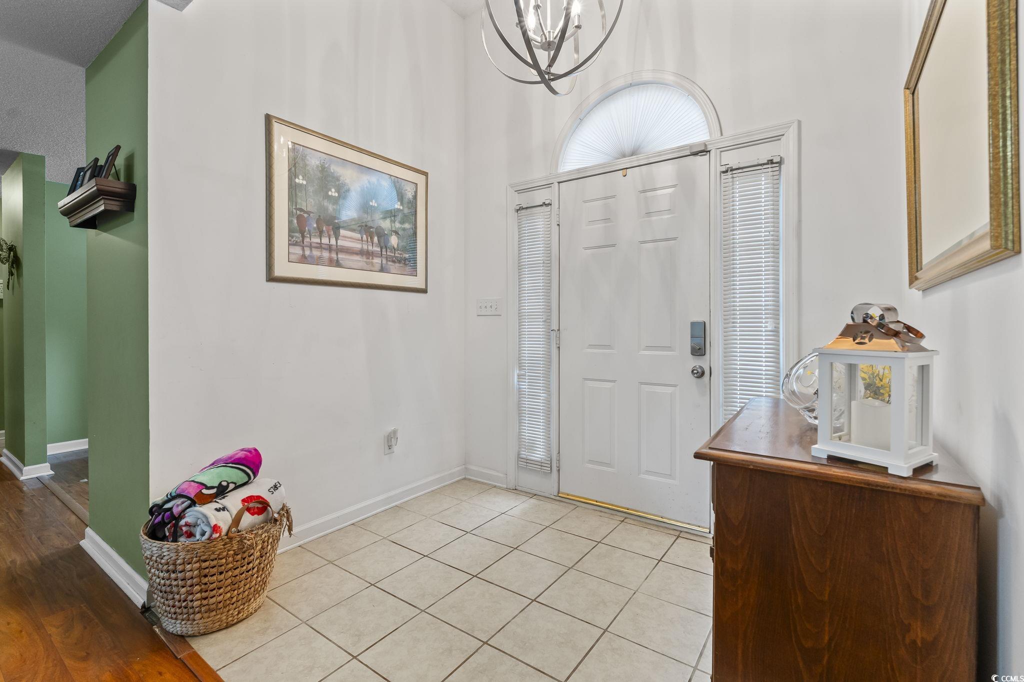 154 Hummingbird Court Myrtle Beach, SC 29579 - Photo 16 of 38 Entrance foyer featuring light tile patterned floors, a chandelier, and a high ceiling