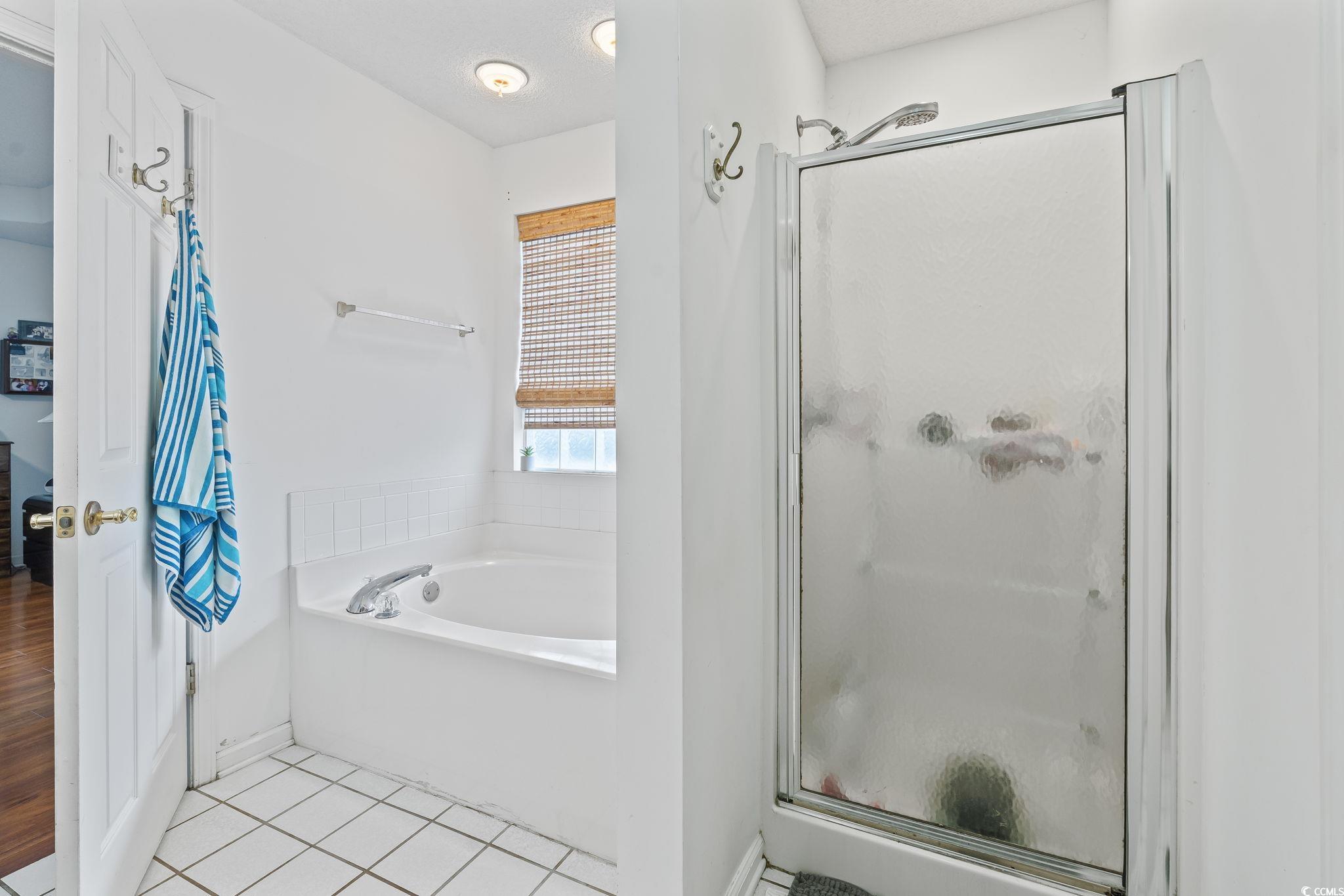 154 Hummingbird Court Myrtle Beach, SC 29579 - Photo 21 of 38 Bathroom featuring light tile patterned floors, a stall shower, and a bath