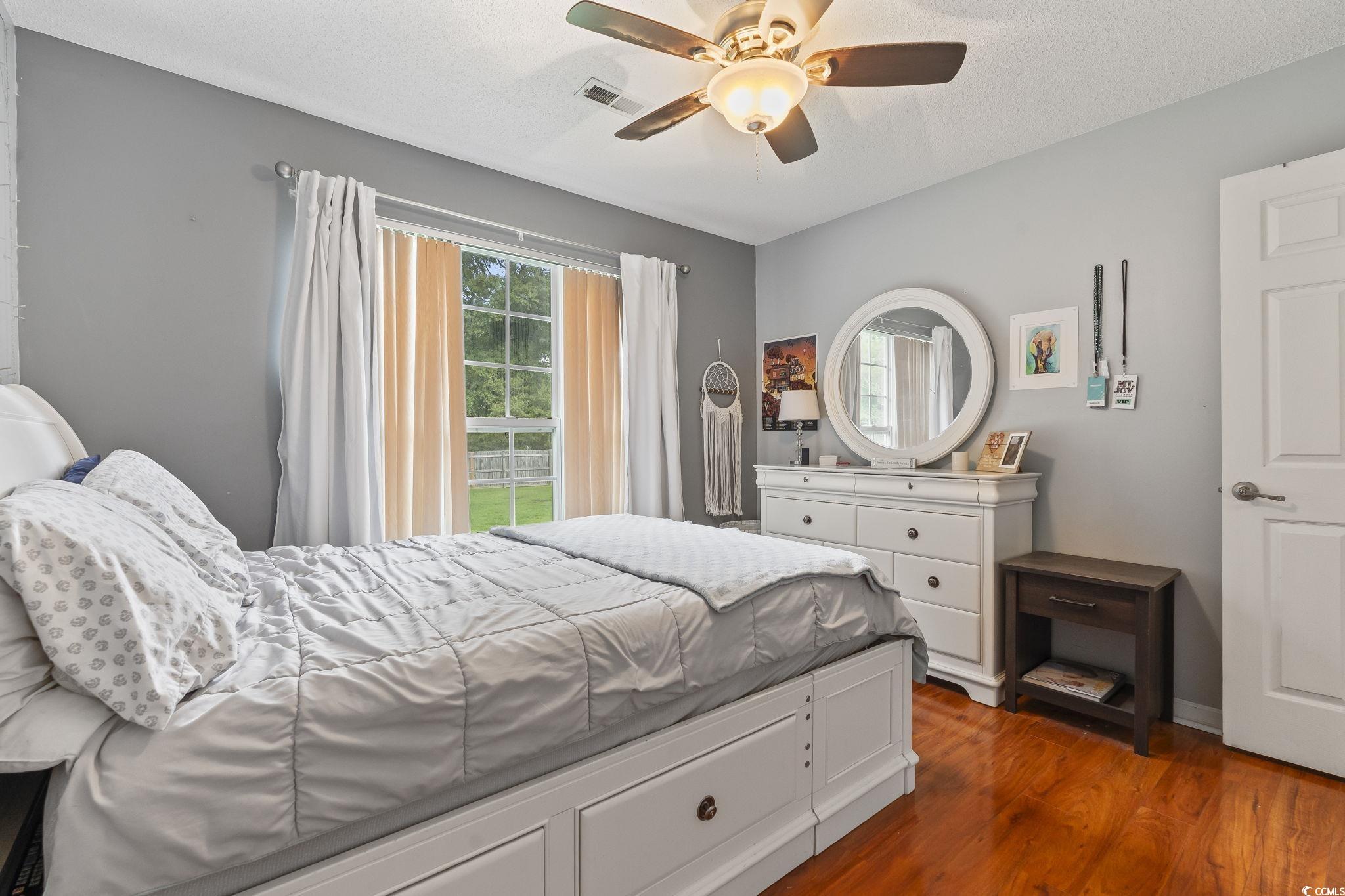 154 Hummingbird Court Myrtle Beach, SC 29579 - Photo 26 of 38 Bedroom featuring dark wood finished floors, a textured ceiling, and ceiling fan