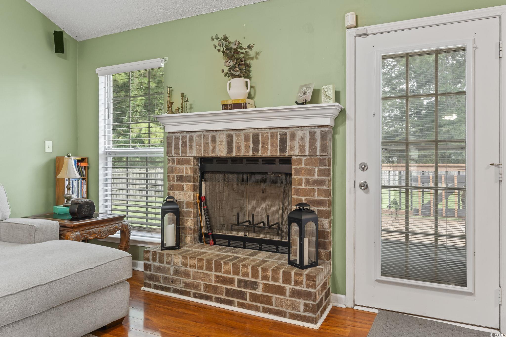 Living area featuring a brick fireplace and wood finished floors