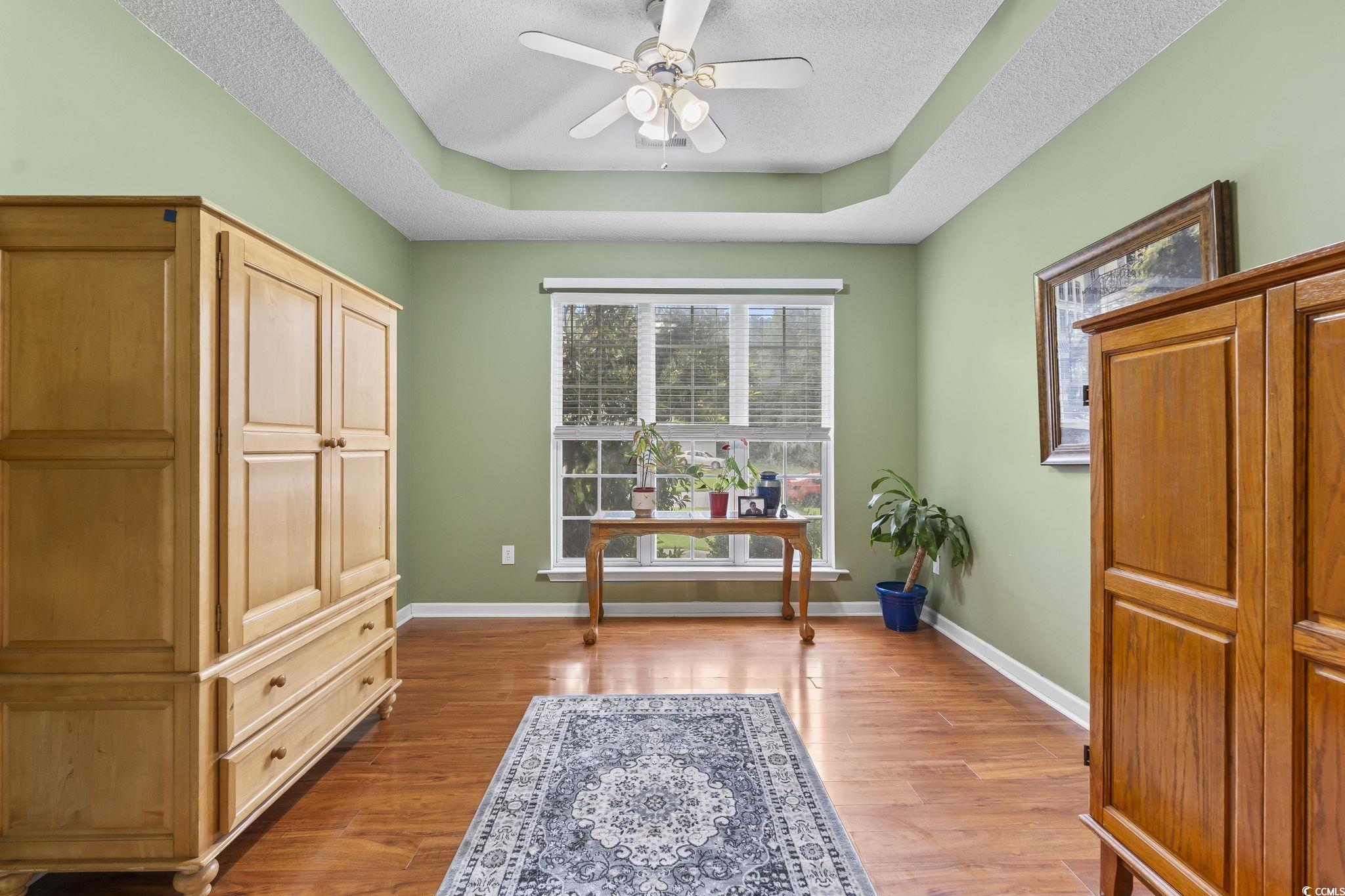 154 Hummingbird Court Myrtle Beach, SC 29579 - Photo 9 of 38 Office space with a tray ceiling, light wood finished floors, a textured ceiling, and a ceiling fan