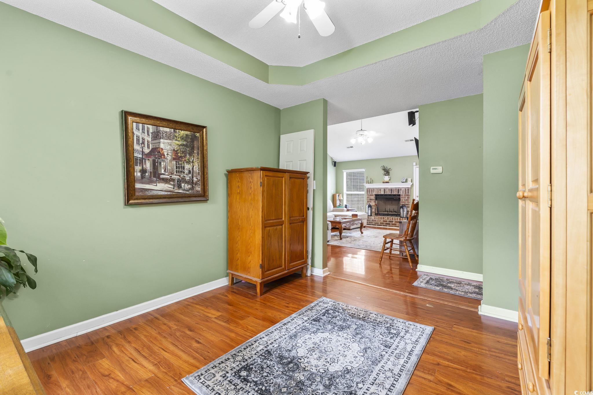 154 Hummingbird Court Myrtle Beach, SC 29579 - Photo 10 of 38 Interior space featuring dark wood-type flooring, a fireplace, and a ceiling fan